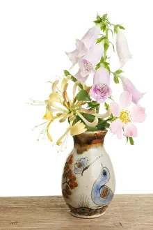 Foxglove Prints: Arrangement of wild flowers in a decorated pot on a wooden bench