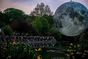 Brighton Prints: Artist Luke Jerram's 7 metre diameter inflatable moon is suspended over the pond at Queens Park in Brighton during