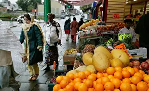Neighbourhood Prints: Asian and Afro Caribbean women pass by a fruit and vegetable store in the Lozells area of Birmingham UK