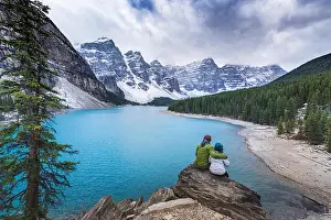 20 25 Prints: Asian couple sitting on rock admiring scenic view of mountain lake