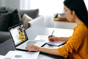 Discussing Prints: Asian female student watching lesson online and studying from home