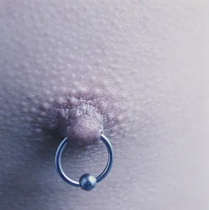 Asian males nipple ring close up