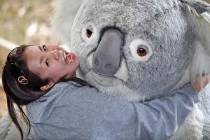 Cuddly Prints: Asian posing tourist with giant koala at the Koala Conservation Centre