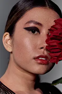 Intense Prints: Asian woman with bold eyeliner, red lipstick, partially obscured by red flower
