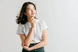 Young Girl Prints: Serious asian woman standing isolated on studio background