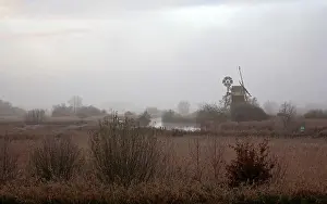 Wetlands Prints: An atmospheric landscape on the Norfolk Broads by the River Ant on a misty December morning with iconic windmill