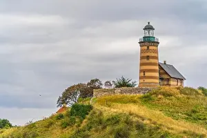 Town Hill Prints: Atop a grassy hill stands a majestic lighthouse against the backdrop of a clear sky