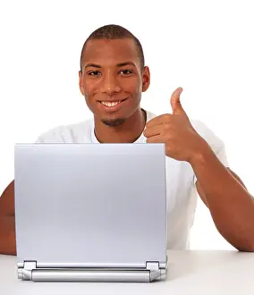 Thumbs Up Prints: Attractive black guy showing thumbs up while using laptop. All on white background