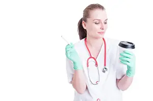 Nicotine Prints: Attractive female doctor wearing uniform smoking and drinking coffee on her break isolated on white with copy space