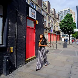 Handbag Prints: Attractive stylish Afro-Caribbean woman walking down street in London, England, UK