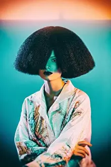 Illuminate Prints: Attractive Woman in oriental silk robe with floral ornament and lavish wig under colorful illumination