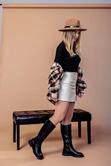 Skirt Prints: An attractive young woman with long blond hair in a beige skirt and black leather boots