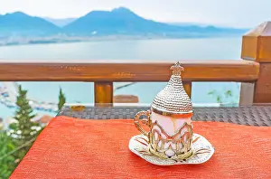 Holder Prints: Authentic Ottoman coffee cup on the table of outdoor restaurant on the Castle Hill slope with the Taurus mountains
