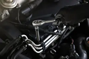Spare Prints: Auto parts. Professional mechanic with torque wrench fixing car indoors, closeup