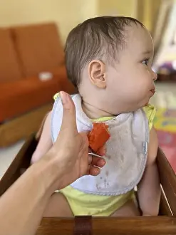 Refuse Prints: Baby eating papaya for the first time. Baby refusing to eat