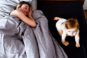 Diaper Prints: Baby girl crawling on bed while mother relaxes
