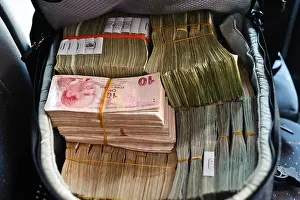 Transaction Prints: A backpack full of New Turkish Lira, laying on the back seat of a car