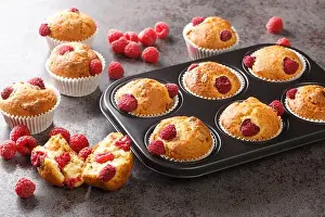 Cupcake Prints: Baked raspberry muffins with white chocolate and fresh berries close-up in a muffin pan on the table