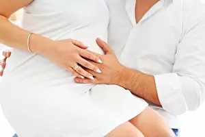 Fondness Prints: Bald adult man touching belly of pregnant woman while resting on comfortable bed in cozy room at home
