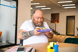 Contented Prints: Bald bearded man in white tshirt holding a lunch box