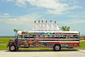 Highways Prints: Six ballerinas dance and balance on top of a Diablo Rojo bus on La Cinta Costera