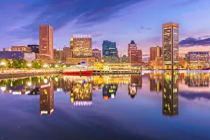 Baltimore, Maryland, USA Skyline on the Inner Harbor with dramatic skies at dusk