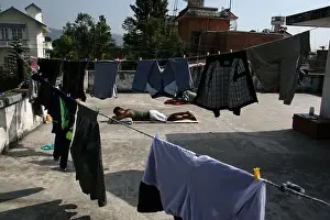 Sunny Weather Prints: Bangladeshi people sleeping on a roof top surrounded by washed cloths drying on lines