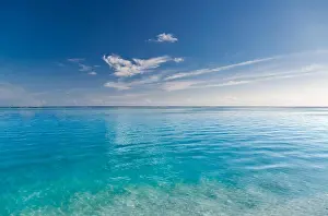 Beach and beautiful tropical sea. Exotic summer sea with blue water. White clouds on a blue sky over summer sea. Tropical sea relax
