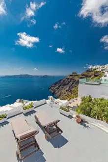 Beach bed chair with towel looking out over the caldera by the swimming pool, Santorini Oia. Luxury chaise lounge, amazing travel destination, summer