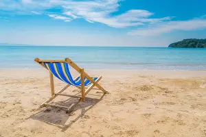 One beach chairs on the white sand with blue sky and summer sea background. Summer, Vacation, Travel and Holiday concept