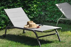 Lounger Prints: Two beach hats and sunglasses of a man and a woman left on a beach lounger