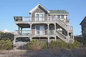 Domicile Prints: A beach house on the Outer Banks at Nags Head, North Carolina, against a bright blue sky