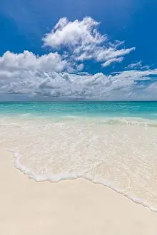 Beach and tropical sea. Relaxing waves splashing with foam on soft white sand. Endless seascape and horizon. Calmness nature landscape under blue sky