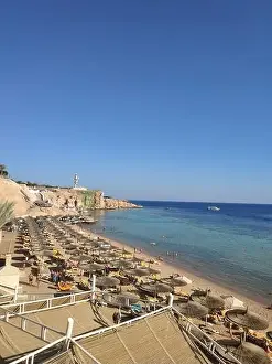 beach with umbrellas on sea with blue water