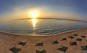 Beauty Day Prints: Beach umbrellas at sunrise. Sea current swims against the waves on the beautiful sea