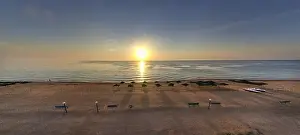Beauty Day Prints: Beach umbrellas at sunrise. Sea current swims against the waves on the beautiful sea