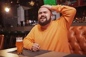 Lumberjack Prints: Bearded man watching football at beer pub, looking upset