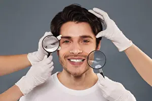 Wrinkles Prints: Beauticians examining young handsome man face through magnifiers