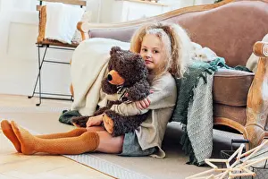 Fashion Model Prints: The beautiful 8 year old girl hugs toy bear and looks at the cam