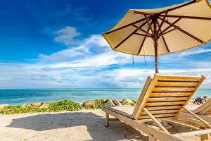 Beautiful beach. Chairs on the sandy beach near the sea. Summer holiday and vacation concept. Tropical beach landscape. Exotic vacation and summer