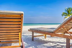 Beautiful beach. Couple chairs on the sandy beach near the sea, blurred island landscape exotic shore coast. Summer holiday and dream vacation concept