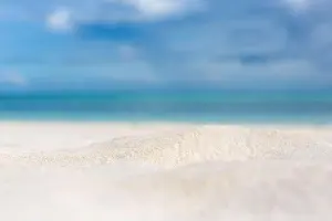Beautiful beach with white sand, turquoise ocean water and blue sky with clouds in sunny day. Seascape abstract beach background. blur bokeh light