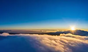 Beautiful bewitching view of mountains and rocks with spruce forest on a frosty winter evening with fog and sunset sun