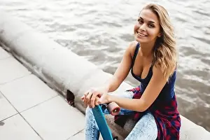 Skateboard Prints: beautiful blonde woman posing with a skateboard in a city park