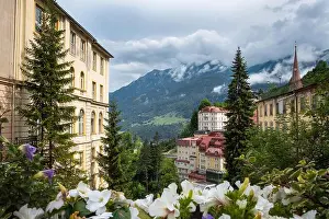 Flowerbed Prints: Beautiful cityscape with flowers and mountains at cloudy summer day in idyllic alp village Bad Gastein