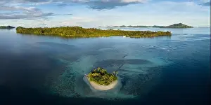 A beautiful coral reef surrounds a scenic island in the Solomon Islands. This beautiful country is home to spectacular marine biodiversity