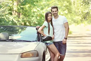 Cabriolet Prints: Beautiful couple standing near car on road
