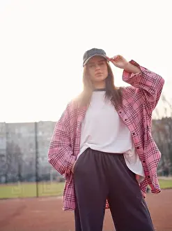 Checkered Prints: Beautiful girl in trendy streetwear fashion posing on basketball court