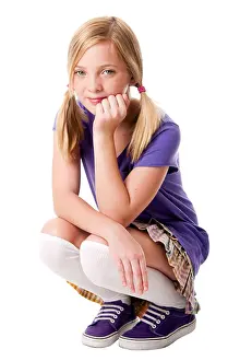 Skirt Prints: Beautiful happy teenage girl sitting squatted wearing knee socks