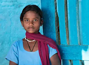Vulnerable Prints: Beautiful indian girl portrait wearing blue top against a blue wall in Kanha village near the Kanha National Park